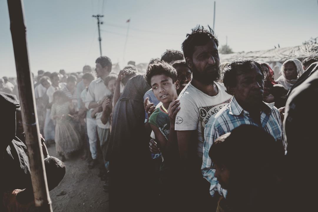 Rohingyan men stand in line for their life vital aid relief